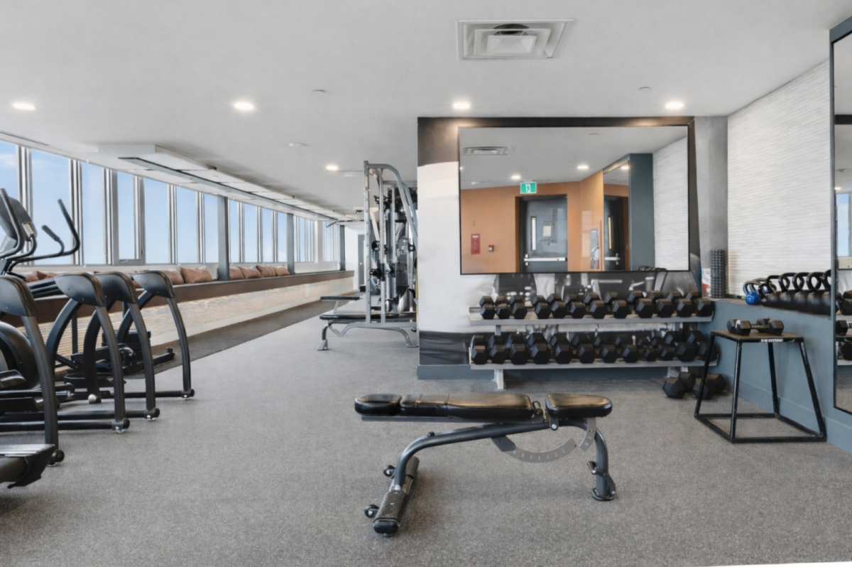Fitness center featuring treadmills, weight machines, and mirrored walls