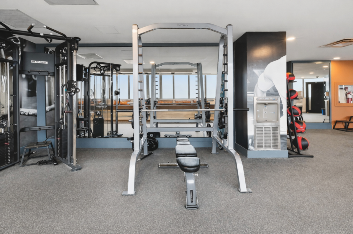 Fitness center featuring treadmills, weight machines, and mirrored walls