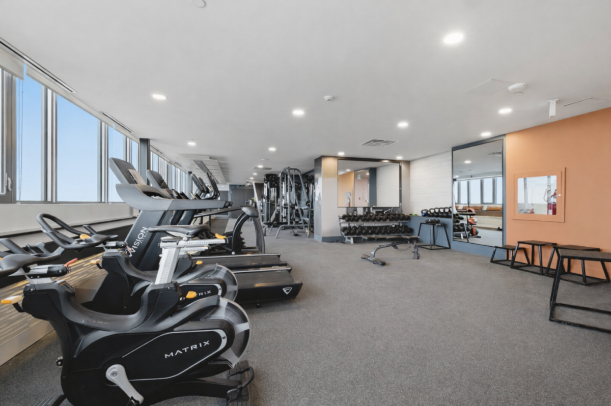 Fitness center featuring treadmills, weight machines, and mirrored walls